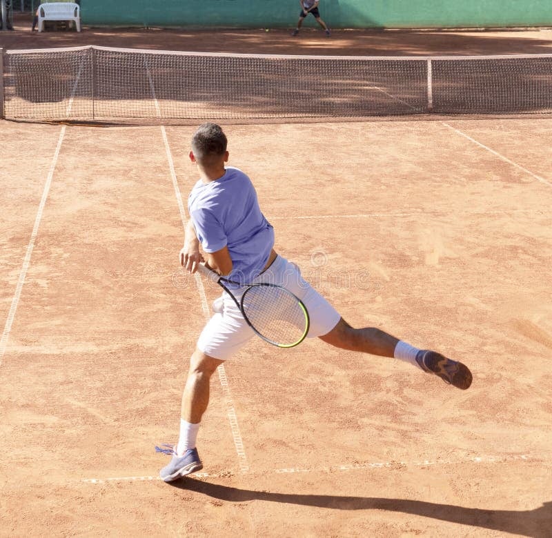 Jogador de tênis executando forehand no saibro
