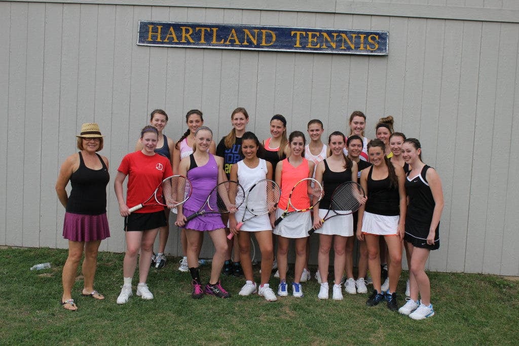 Veteran tennis coach with players