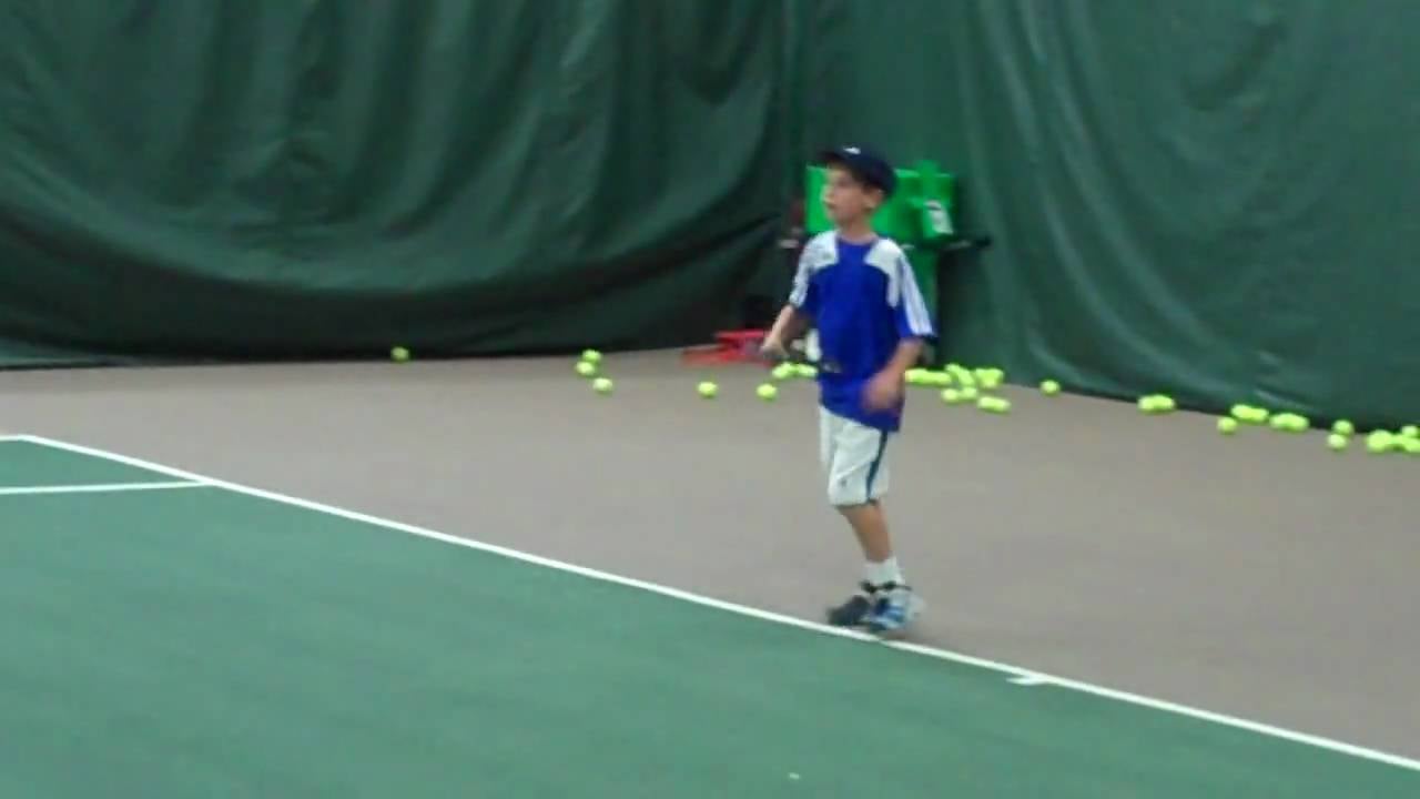 Criança executando forehand no tênis infantil