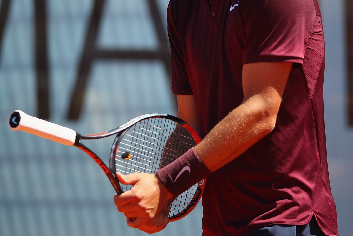 Bernard Tomic holding racket backwards on match point Madrid Open 2016