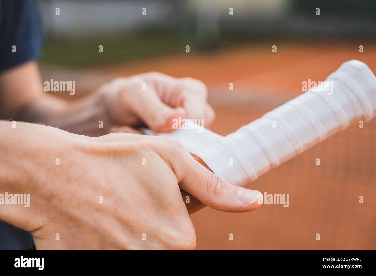Close-up de aplicação de overgrip em raquete de tênis